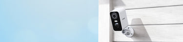 ieGeek smart home battery security camera ZY-C1 mounted on a wall with a clear sky background